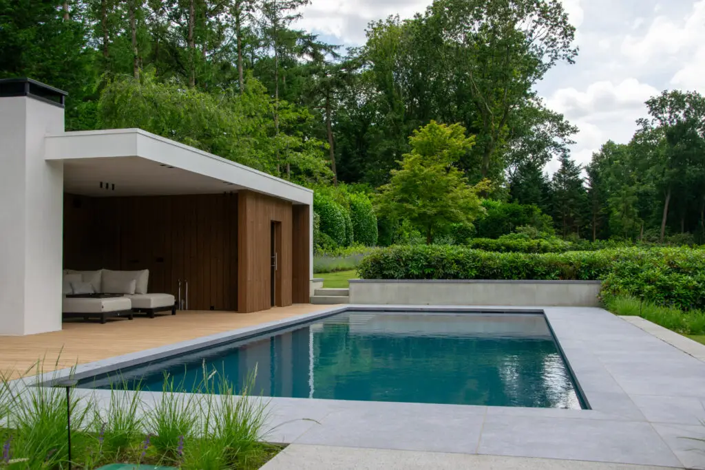 Impressie van een tuin met een skimmer zwembad met een hoogwaterlijn.