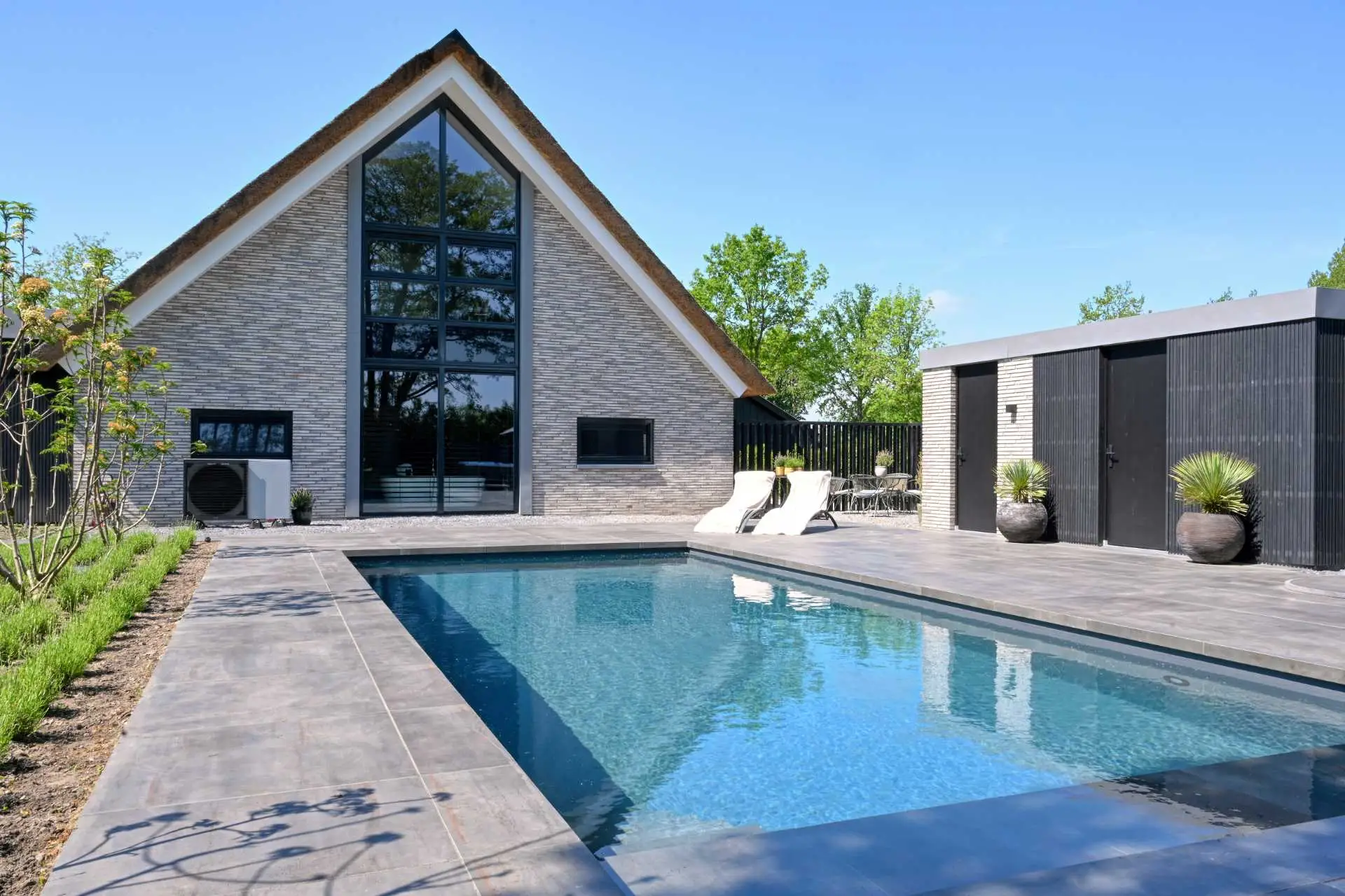 Impressie van een villa en een tuin met een betonnen zwembad.