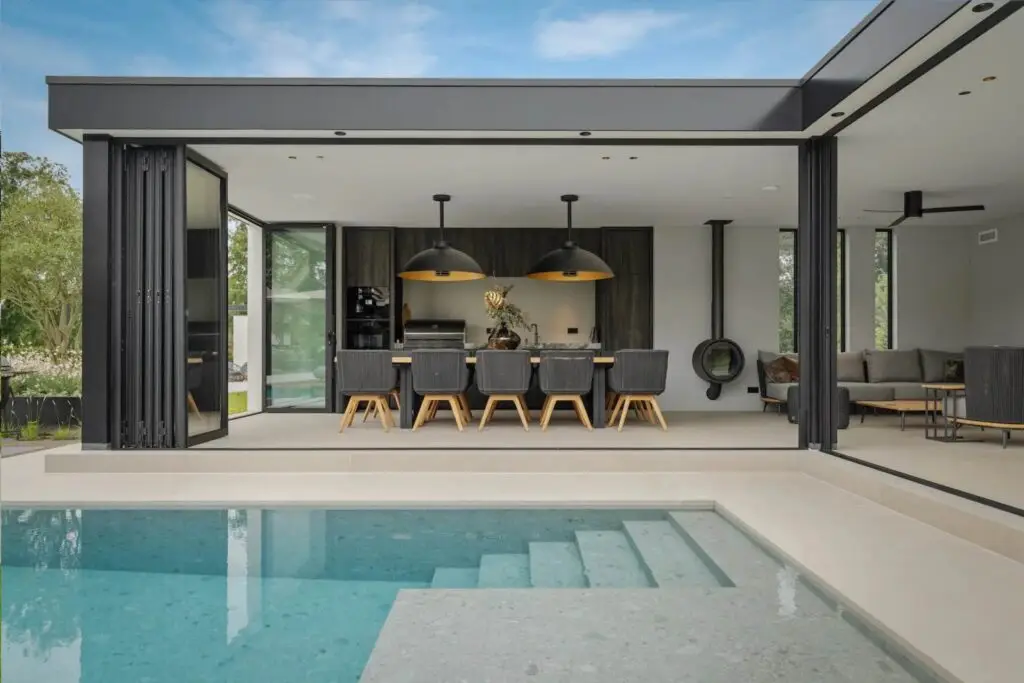 Impressie van een infinity edge pool met een trap, gelegen naast een poolhouse.