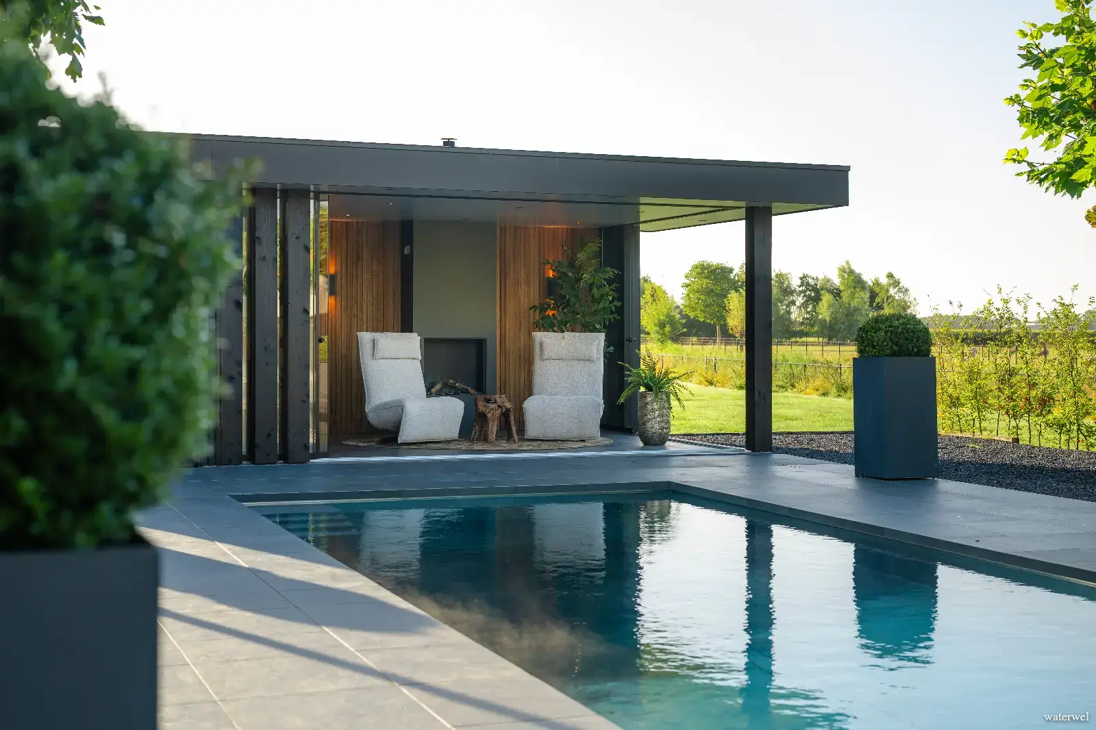 Sfeervol RVS zwembad van Waterwel met strakke randafwerking en uitzicht op landelijke omgeving.